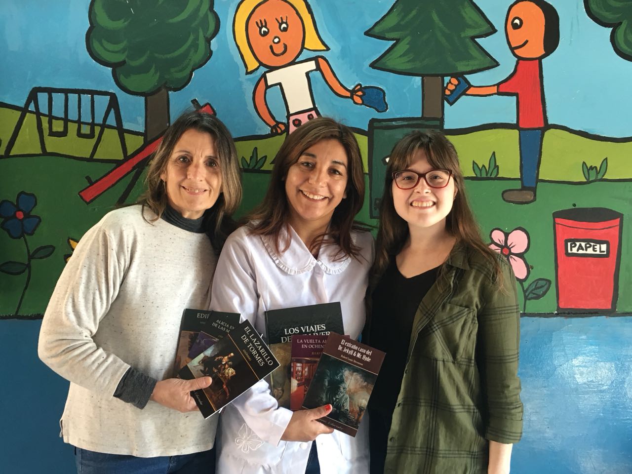 Carolina Semmoloni (CIPPEC) junto a dos mujeres que sostienen libros